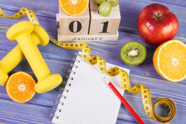 1 Ocak'ta küp takvim, olgun meyve, halter ve şerit metre, sağlıklı yaşam tarzı yeni yıl kararları