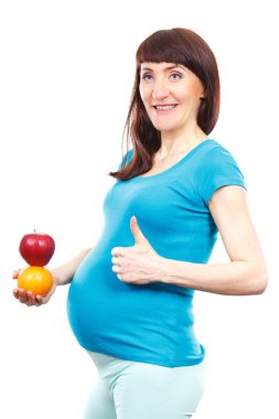 Taze olgun meyveler tutan ve başparmak gösteren hamile Mutlu kadın, gebelik sırasında sağlıklı gıda ve beslenme kavramı, yenidoğan için bekliyor