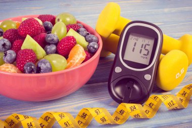 Taze meyve salatası, şekerini, mezura ve dumbell sonucu, diyabet, spor, diyet, zayıflama, sağlıklı yaşam ve beslenme kavramı ile şekeri ölçüm cihazı
