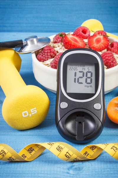 Glucose meter with result of sugar level, oat flakes with fruits, centimeter and dumbbells for fitness, concept of diabetes, diet, and healthy, sporty lifestyles