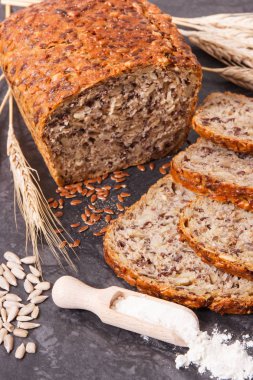 Taze pişmiş kepekli ekmek, pişirme malzemeleri ve çavdar ya da buğday taneleri.