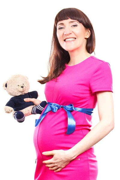 ドレス子供用ふわふわテディベアを保持して 新生児用を期待して 家族を拡張する幸せの笑みを浮かべて妊娠中の女性 — ストック写真