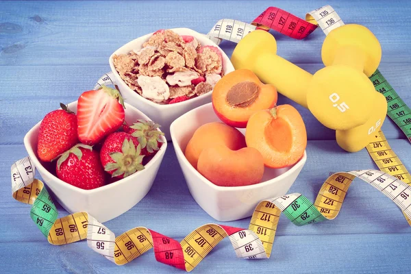 Buğday ve çavdar pul, fitness ve şerit metre, zayıflama, kavramı dumbbells ile taze meyve sportif, sağlıklı yaşam tarzı