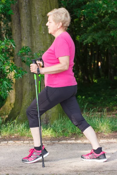 Starší starší žena cvičí na nordic walking, Sportovní životní styl na čerstvém vzduchu ve stáří — Stock fotografie