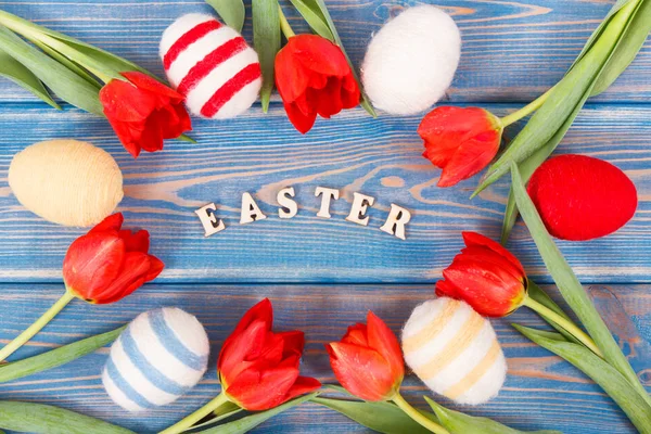 郁金香和鸡蛋裹在木板上的羊毛串作为节日复活节装饰 — 图库照片