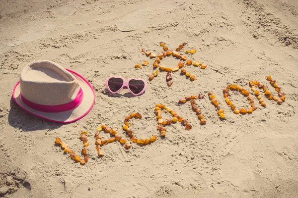 Palabra de vacaciones con forma de gafas de sol y sombrero de paja en la playa, concepto de hora de verano — Foto de Stock