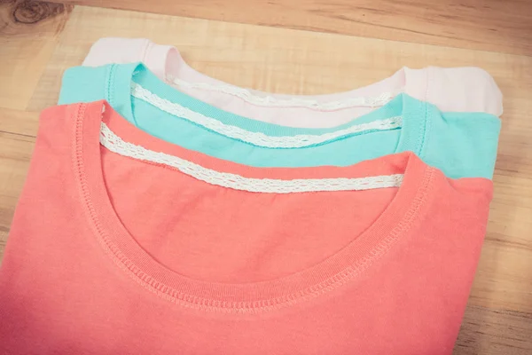 Camisas coloridas o suéter para mujer en tablero rústico —  Fotos de Stock