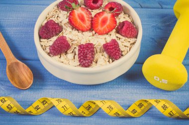Meyve, halter ve santimetre, zayıflama, diyet ve sağlıklı yaşam konsepti ile yulaf gevreği