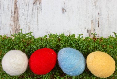 Paskalya yumurtaları gemide, kopya alanı için metin, Paskalya için dekorasyon yün dize ve yeşil cress sarılmış