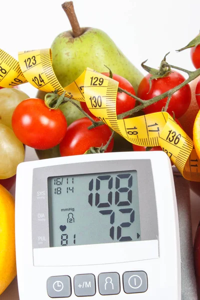 Monitoraggio della pressione sanguigna con risultato della misurazione, frutta fresca con verdure e centimetro, stile di vita sano — Foto Stock