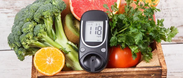 Glucose meter with healthy fruits and vegetables. Checking sugar level, diabetes, diet and slimming concept