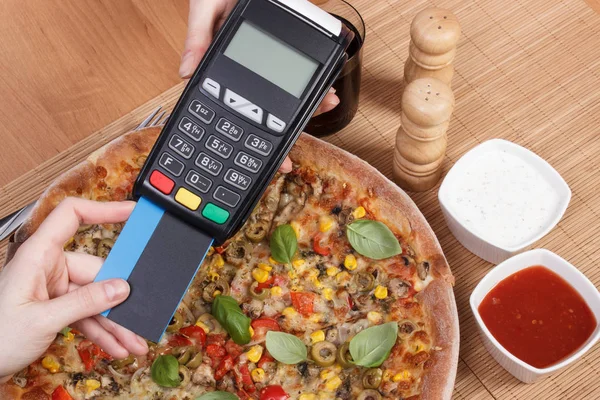 Использование кредитной карты и платежного терминала для оплаты в ресторане, финансовой концепции, вегетарианской пиццы — стоковое фото