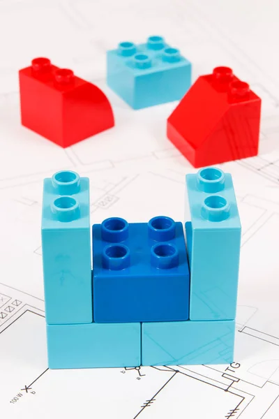 Bloques de juguete coloridos y plan de vivienda de construcción. Concepto de construcción, compra o alquiler de viviendas — Foto de Stock