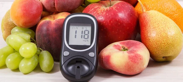 Glukos mätare med resultat socker nivå och frukter som innehåller vitaminer för en hälsosam livsstil hos diabetiker — Stockfoto