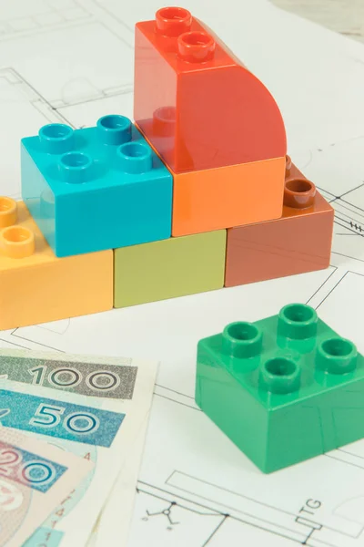 Renkli oyuncak blokları, lehçe banknot ve ev inşaat çizimleri. Ev konsepti satın alma veya kiralama — Stok fotoğraf