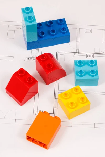 रंगीत खेळणी ब्लॉक आणि बांधकाम गृहनिर्माण योजना. घर संकल्पना इमारत, खरेदी किंवा भाड्याने — स्टॉक फोटो, इमेज