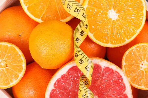 Fresh juicy fruits as source minerals or vitamins and tape measure. Dieting, slimming and healhy lifestyles — Stock Photo, Image