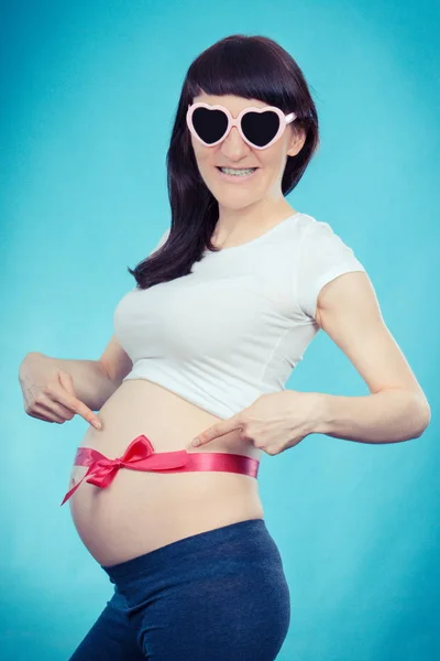 Leende kvinna i gravid med rosa band, begreppet förväntar sig för nyfödda flicka — Stockfoto