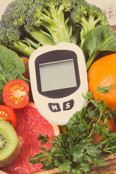 Glucose meter for measuring sugar level and fruits and vegetables. Concept of diabetes, healthy lifestyles and nutrition