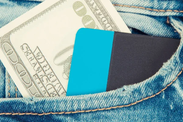 Monedas dólar y tarjeta de crédito en bolsillo vaquero. Elección entre pago en efectivo o sin efectivo — Foto de Stock