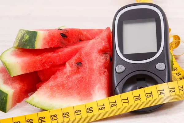 Watermelon, glucometer for measuring sugar level and tape measure, diabetes, healthy lifestyles and slimming concept