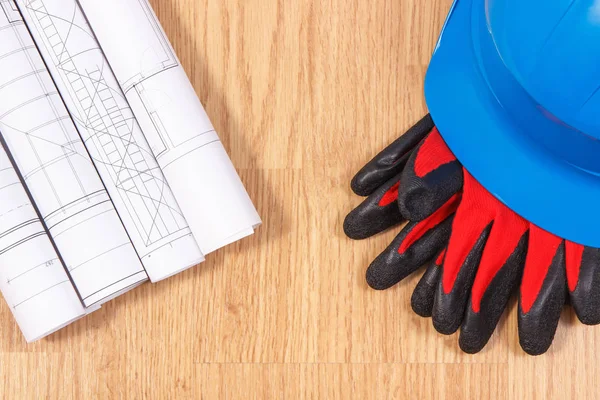 Rolos de plantas ou desenhos eléctricos, capacete azul de protecção e luvas, acessórios para trabalhos de engenharia — Fotografia de Stock