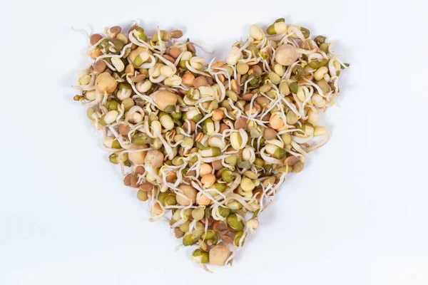 扁桃和鹰嘴豆健康发芽，心脏形状含有维生素和矿物质。白色背景 — 图库照片
