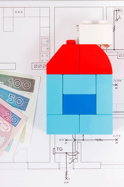 Coloridos bloques de juguete en forma de casa, dinero de moneda polaco y plan de vivienda de construcción. Comprar o alquilar el concepto de casa — Foto de Stock