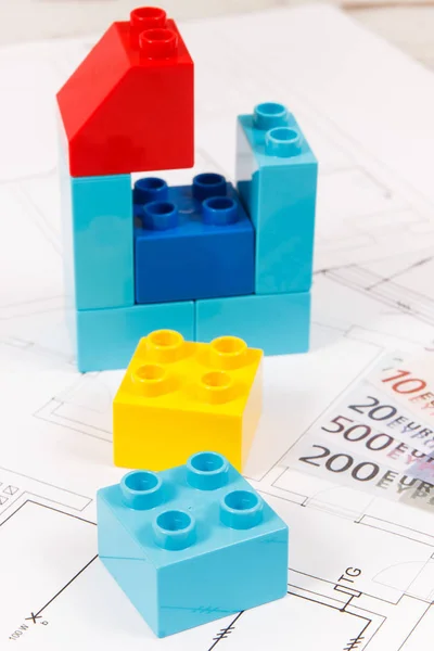 家、通貨ユーロと建設住宅計画の形でカラフルなおもちゃのブロック。住宅の概念を購入または借りる — ストック写真