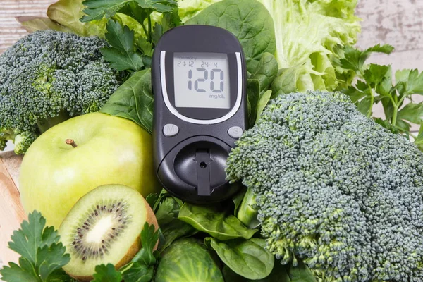 Glucometer for measuring sugar level and green fruits with vegetables. Diabetes, dieting and body detox concept