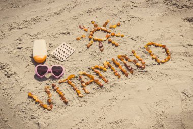 Tıbbi haplar, yazıt D vitamini ve plajda kum güneşlenmek için aksesuarlar