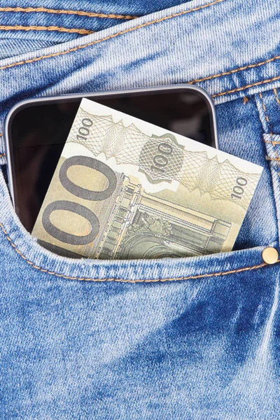 Argent avec téléphone portable dans la poche du jean. Paiement sans espèces ou en espèces pour le concept de magasinage — Photo
