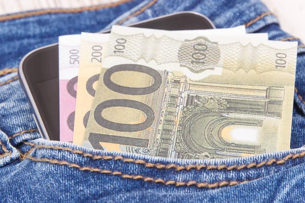 Monedas euro y teléfono móvil para pagar en efectivo en bolsillo de jeans. Finanzas y banca — Foto de Stock