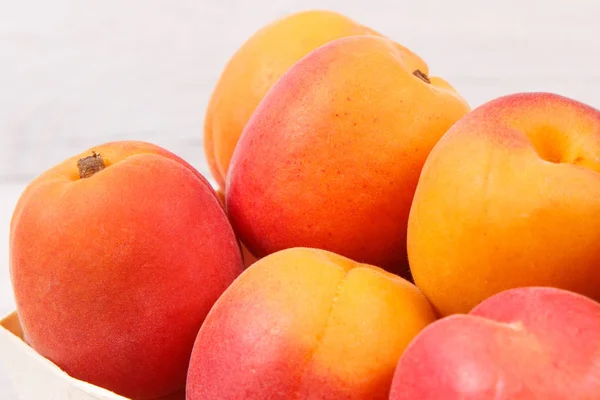 Apricot or peach in wooden box as healthy snack or dessert. Food containing vitamins and minerals — Stock Photo, Image