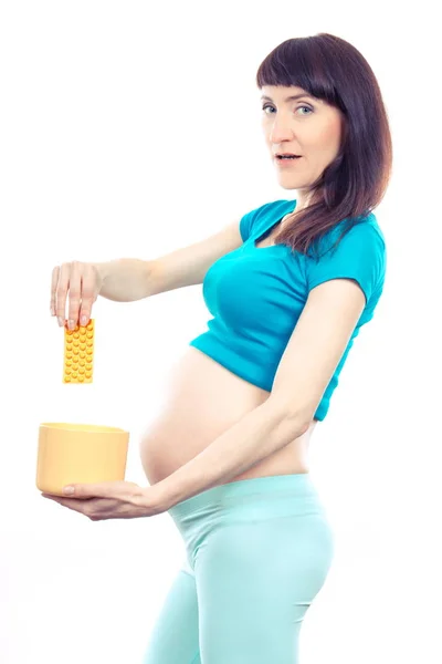 Женщина при беременности бросает медицинские таблетки или капсулы, уменьшает использование таблеток во время беременности — стоковое фото