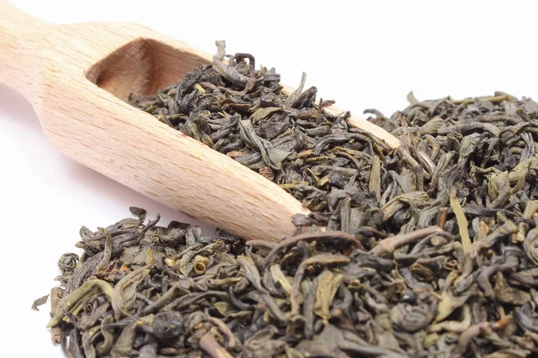 Torkat grönt te med sked på vit bakgrund. Hälsosamma livsstilar — Stockfoto