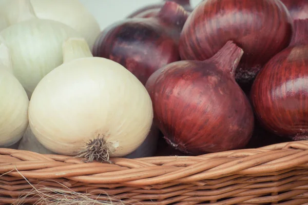 Montón de cebollas maduras en canasta de mimbre, nutrición saludable y concepto de cosecha vegetal — Foto de Stock