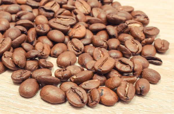 Un mucchio di chicchi di caffè su tavola di legno — Foto Stock