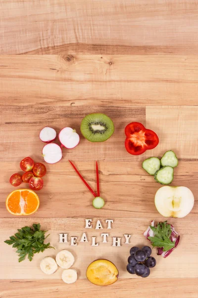 Reloj hecho de frutas y verduras que muestra el tiempo de 23 horas 55 minutos, concepto de resoluciones de año nuevo — Foto de Stock