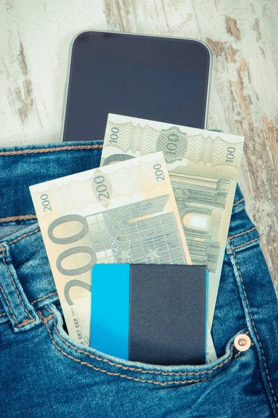 Tarjeta de crédito, monedas en euros en el bolsillo de jeans y smartphone. Concepto de pago en efectivo o sin efectivo — Foto de Stock