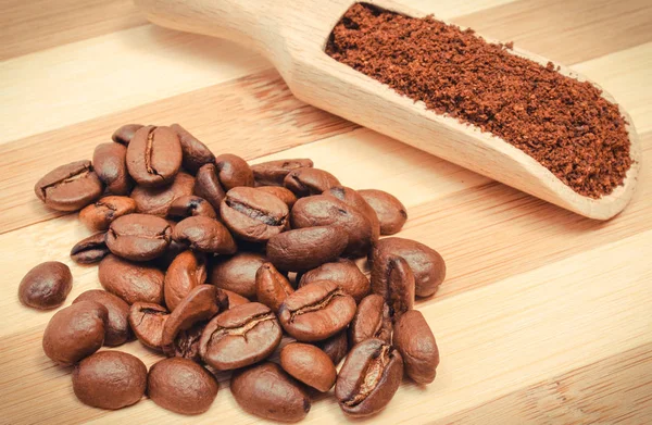 Ground and coffee grains on wooden background