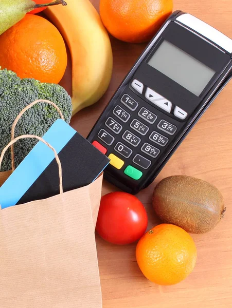 Платіжний термінал, безконтактна кредитна картка, паперова сумка та фрукти з овочами — стокове фото