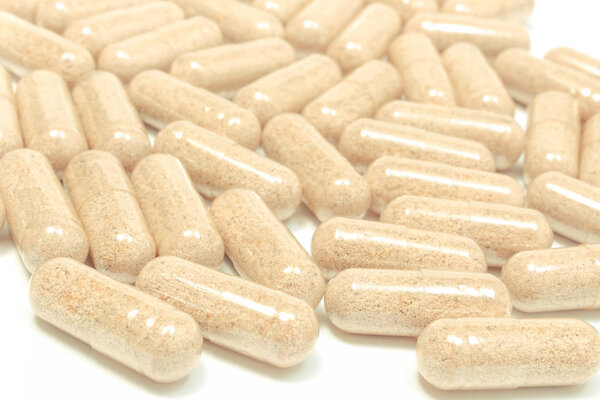 Лекарственные таблетки или капсулы на белом фоне
