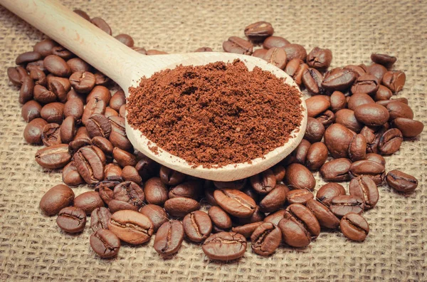 Jord och kaffe korn med sked på jute säckväv — Stockfoto