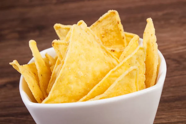 Salted potato crisps in bowl on board, concept of unhealthy food — Stock Photo, Image