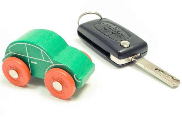 Grünes Spielzeugauto und Fahrzeugschlüssel auf weißem Hintergrund — Stockfoto