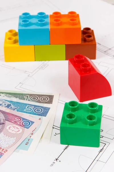 Plastic speelgoed blokken, Poolse valuta geld en bouw diagrammen van huis — Stockfoto