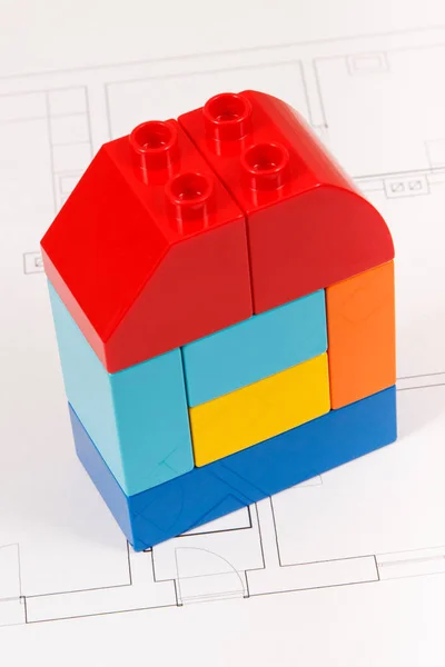 Coloridos bloques de juguetes y dibujos de construcción de la casa. Concepto de construcción, compra o alquiler de viviendas — Foto de Stock