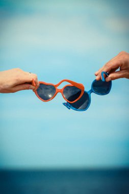 Kalp şeklinde güneş gözlüğü ile Eller. Yaz saati ve seyahat konsepti