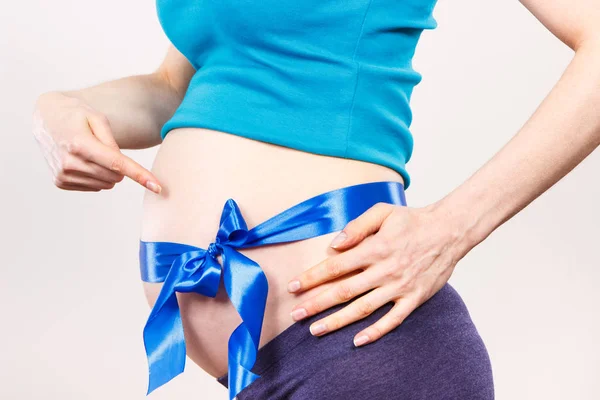 Zwangere vrouw toont buik met blauw lint, concept van verwachten voor pasgeboren jongen — Stockfoto